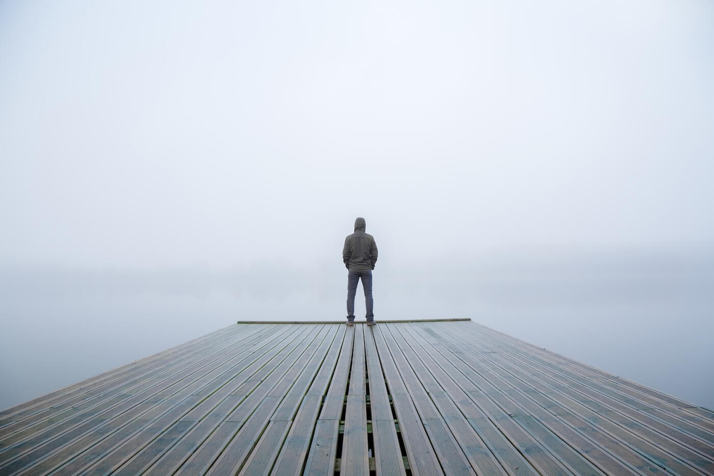 Young man standing alone at the edge of a footbridge